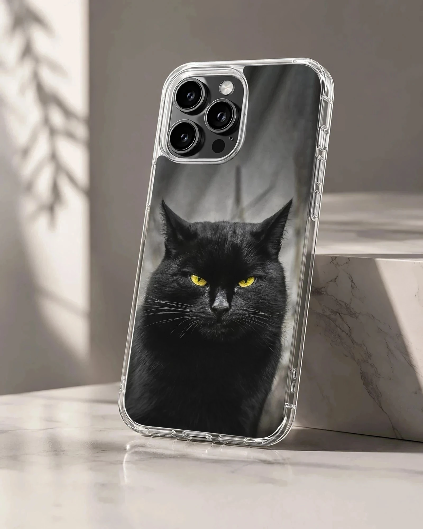 Black cat with piercing yellow eyes on a phone case