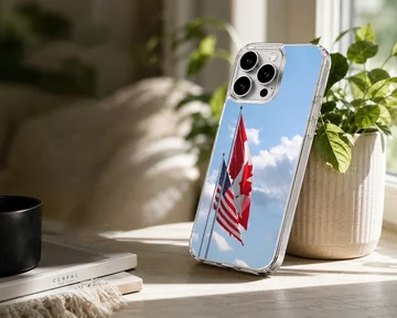 Canadian and American flags waving against a bright blue sky on a phone case — Lifestyle