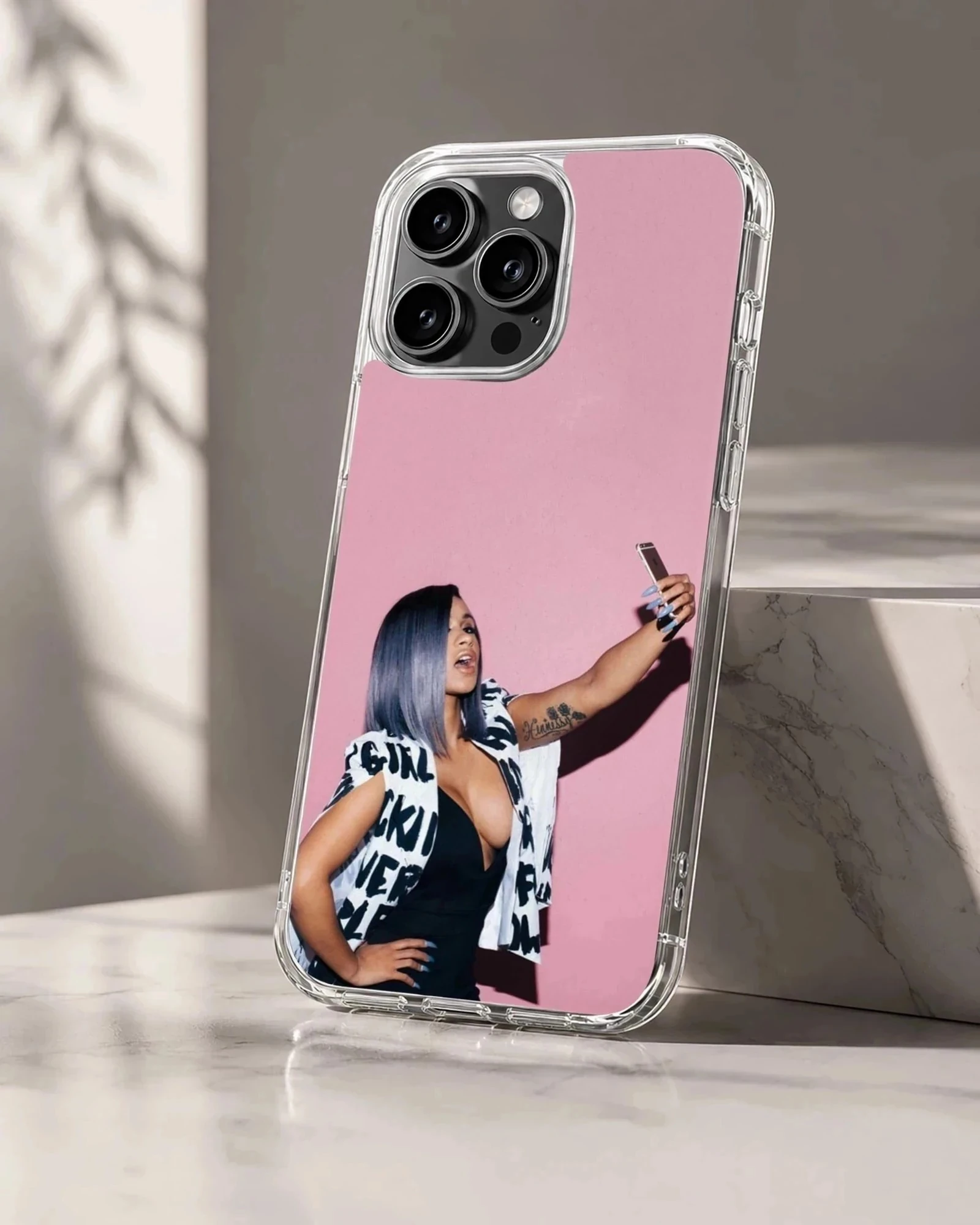 Cardi B taking a selfie in front of a pink wall printed on a phone case