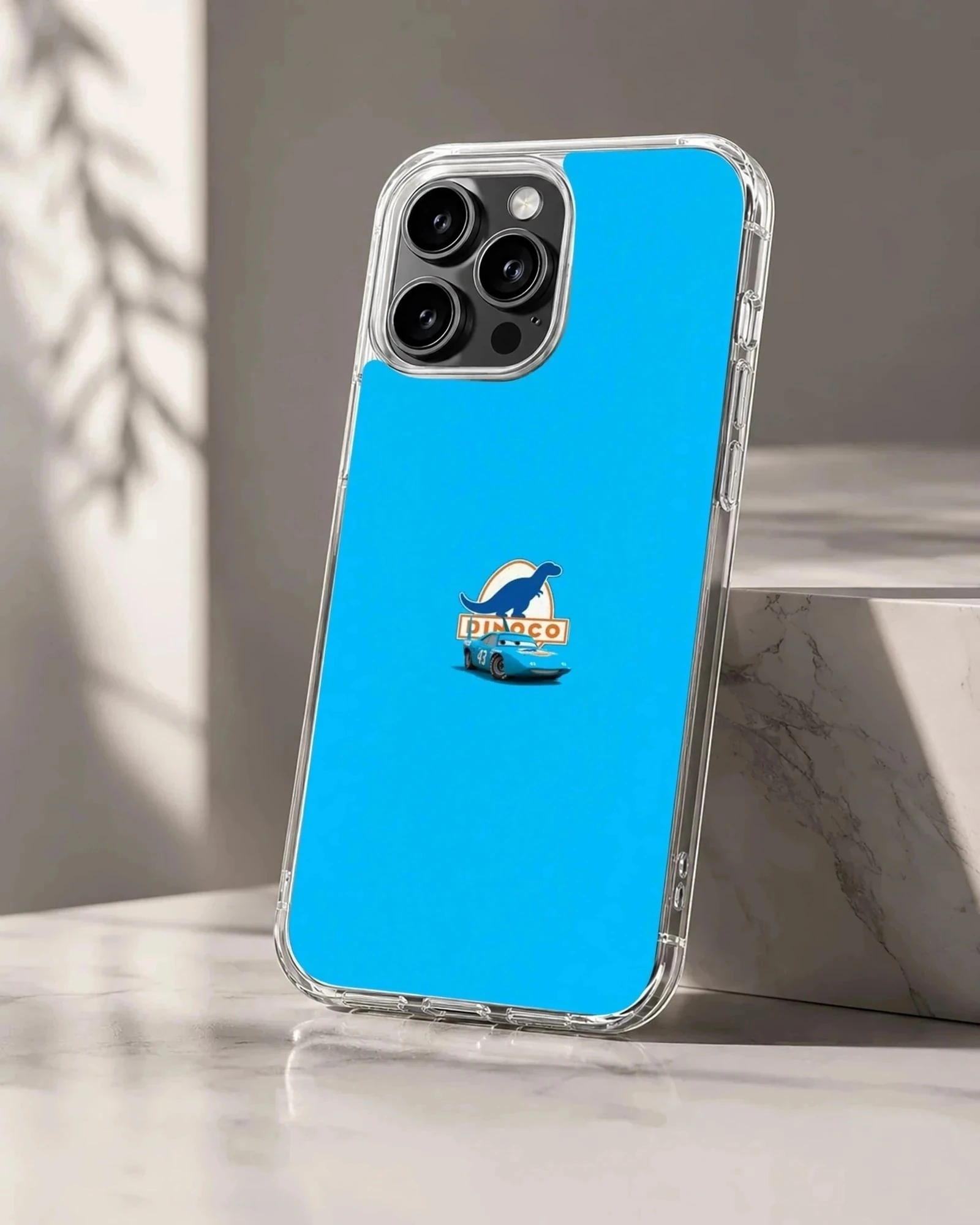 A vibrant blue phone case featuring a small race car and dinosaur logo graphic in the center.
