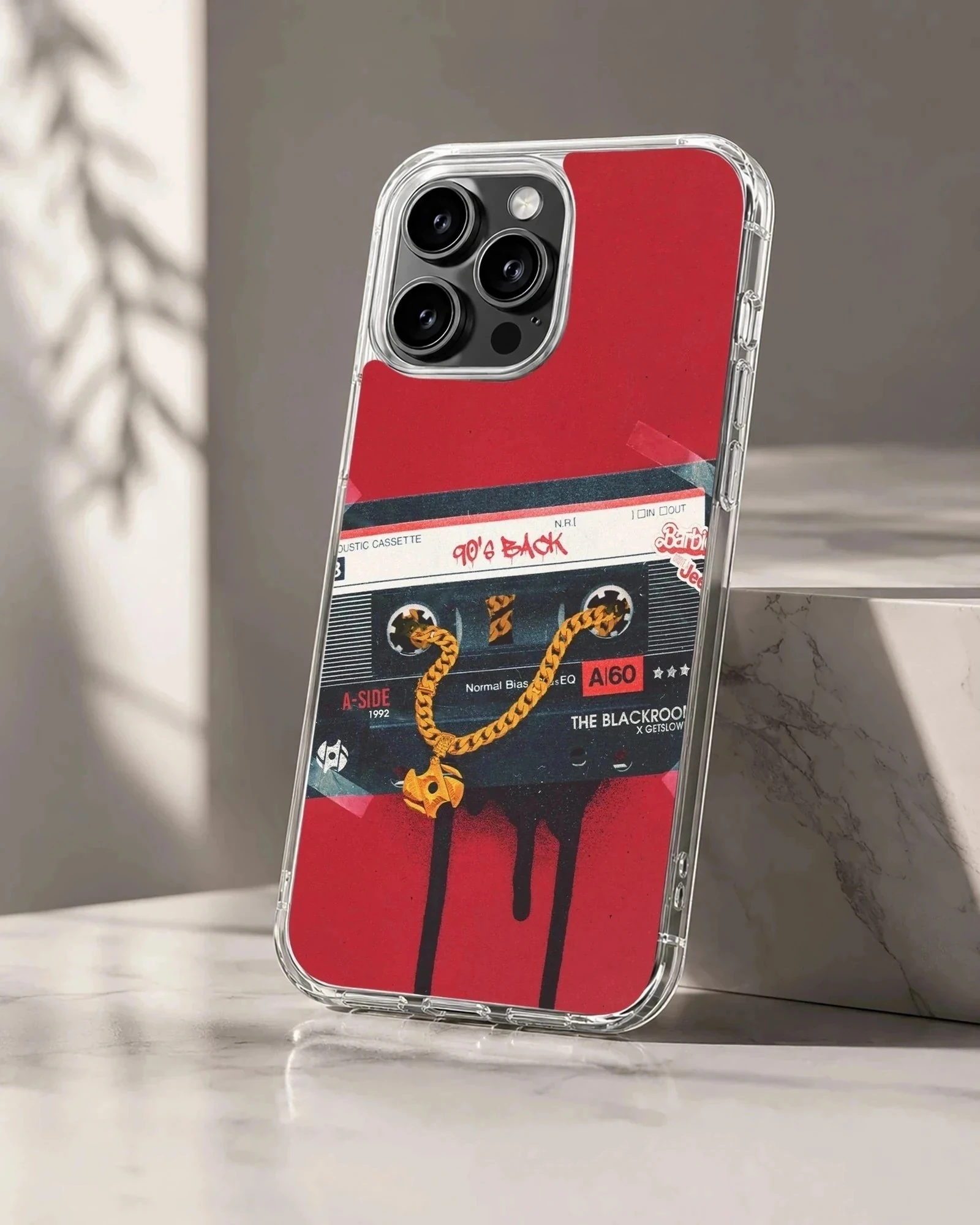 Retro cassette tape graphic with a gold chain on a red background phone case