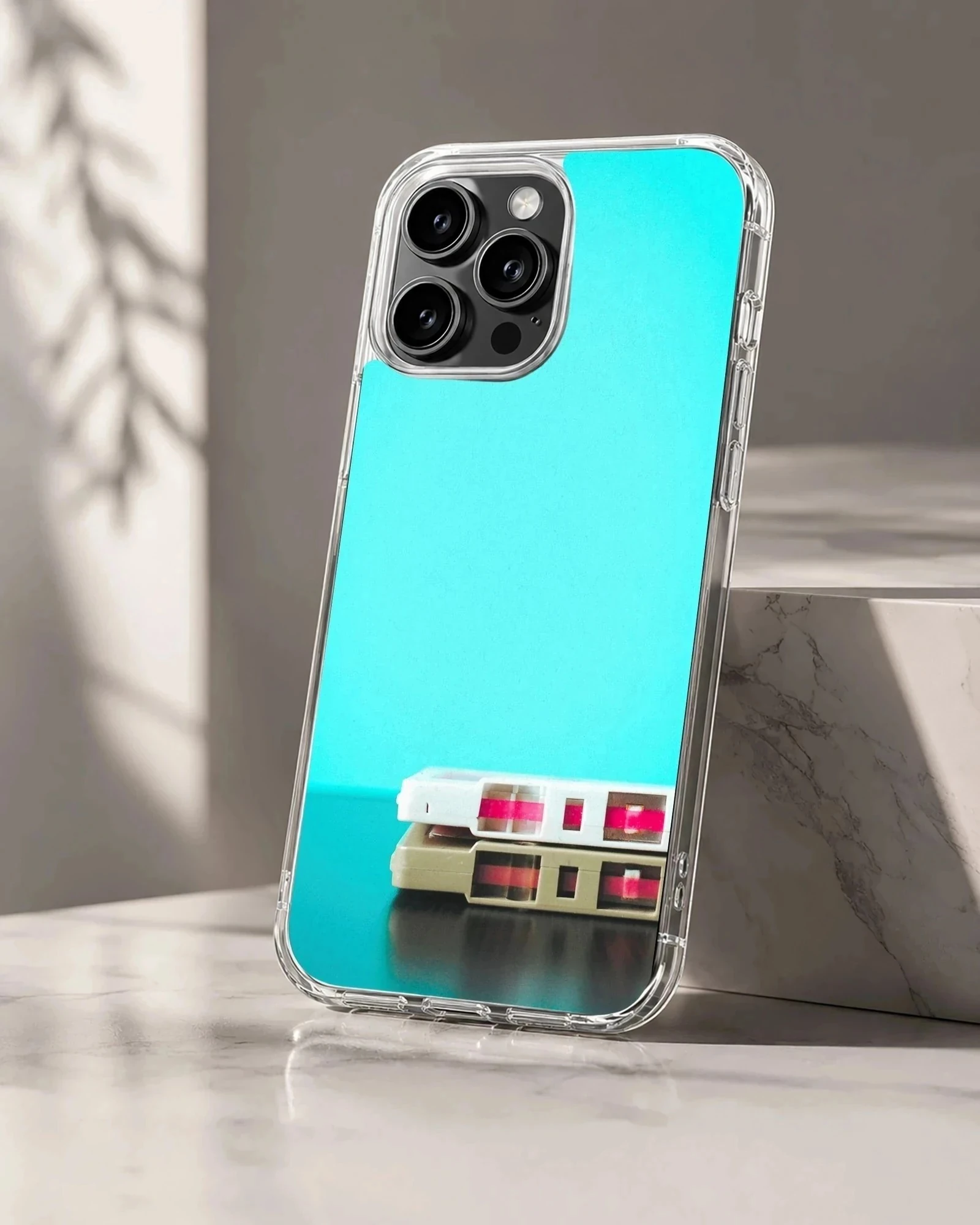 Stacked vintage cassette tapes against a vibrant turquoise background on a phone case
