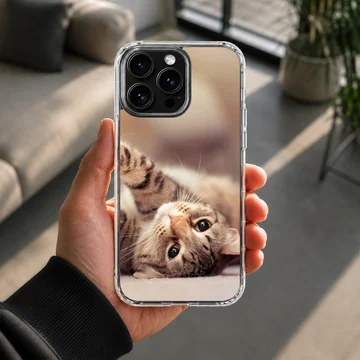 Close up photo of an adorable tabby cat lying on its back on a phone case — Lifestyle