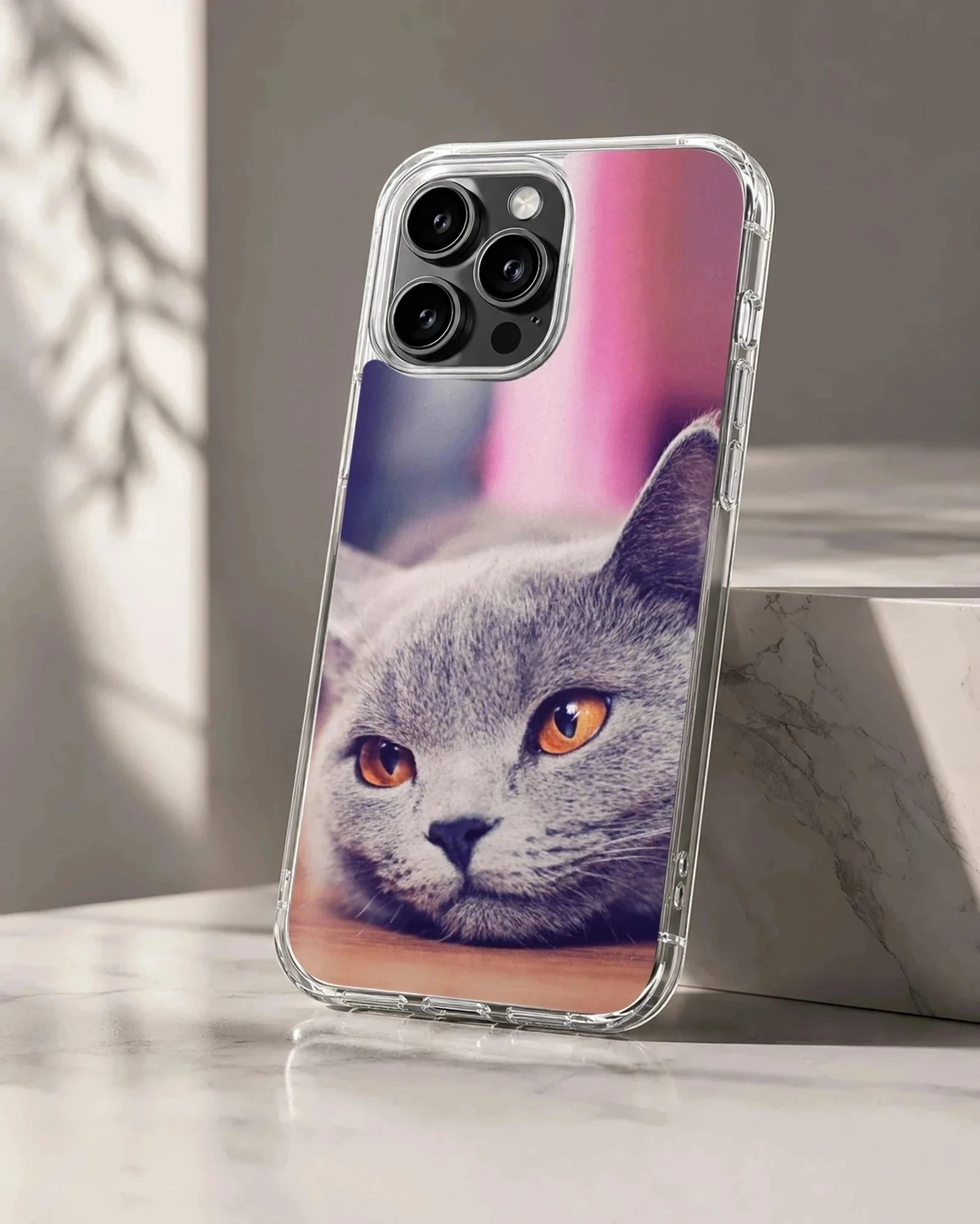 Close-up photographic print of a grey cat with bright amber eyes on a phone case