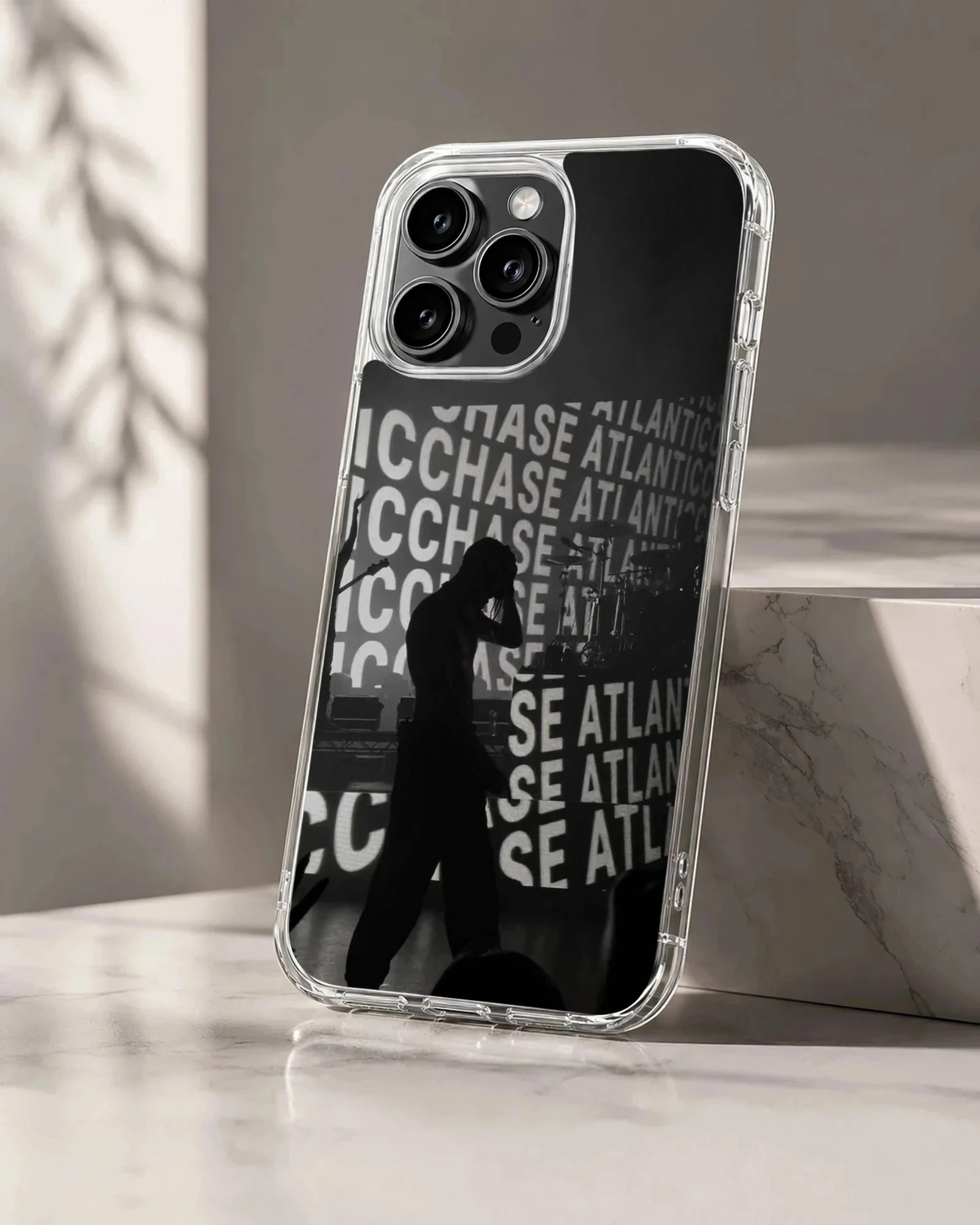A black and white concert silhouette phone case featuring repeating typography in the background.