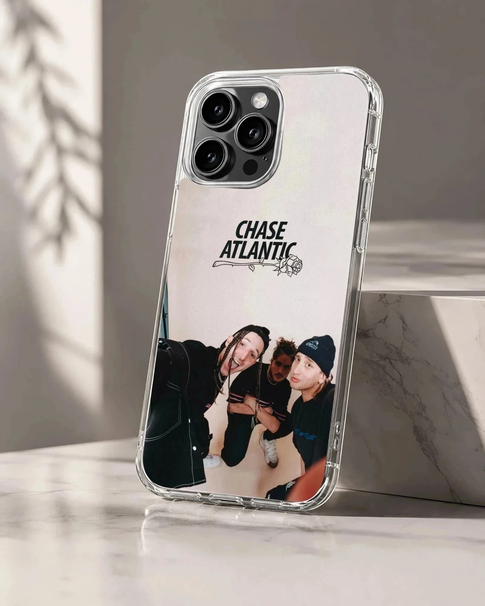 Chase Atlantic band members in a group photo with a rose logo above on a phone case