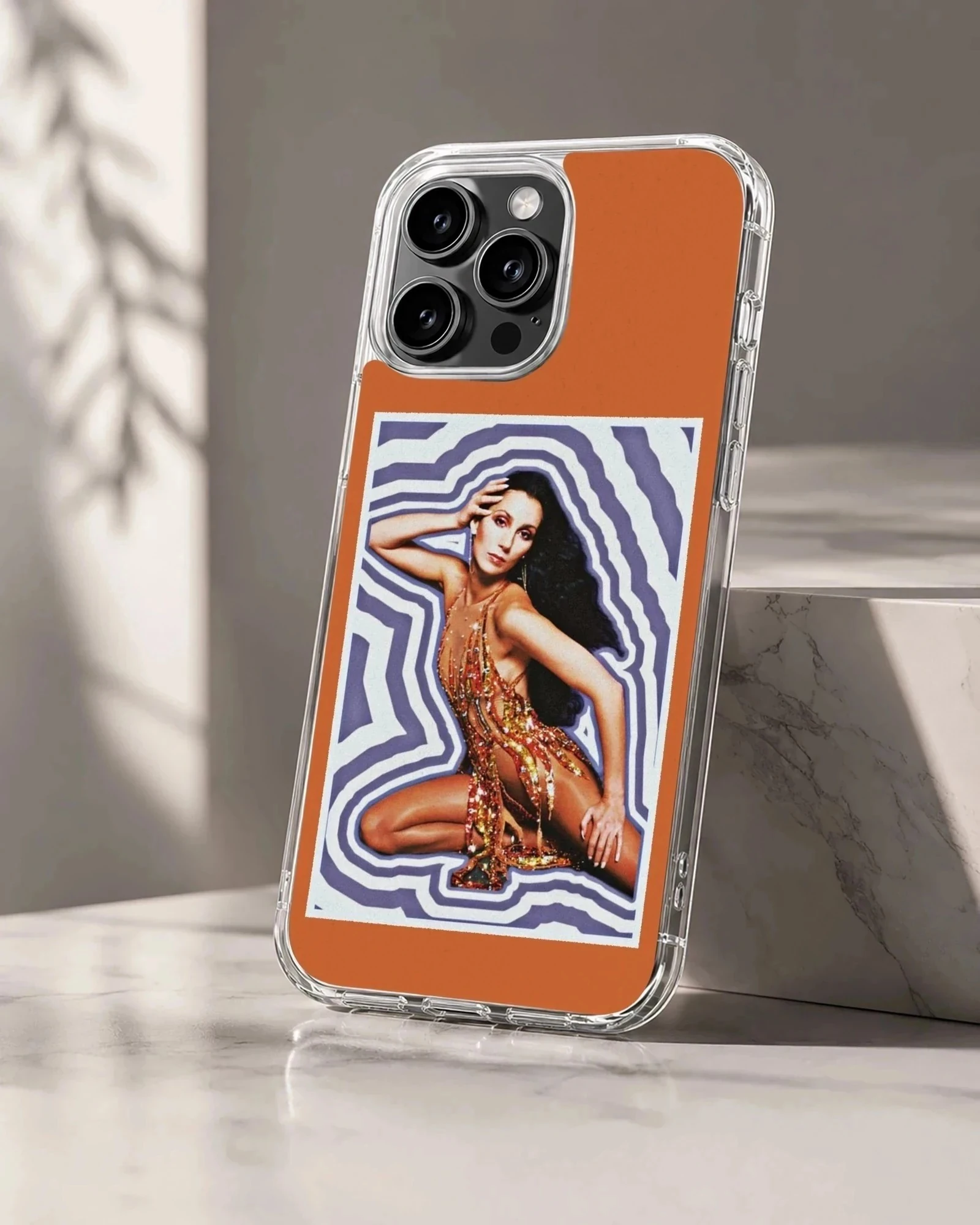 Cher portrait in a glittering stage outfit against a purple wavy background on a phone case