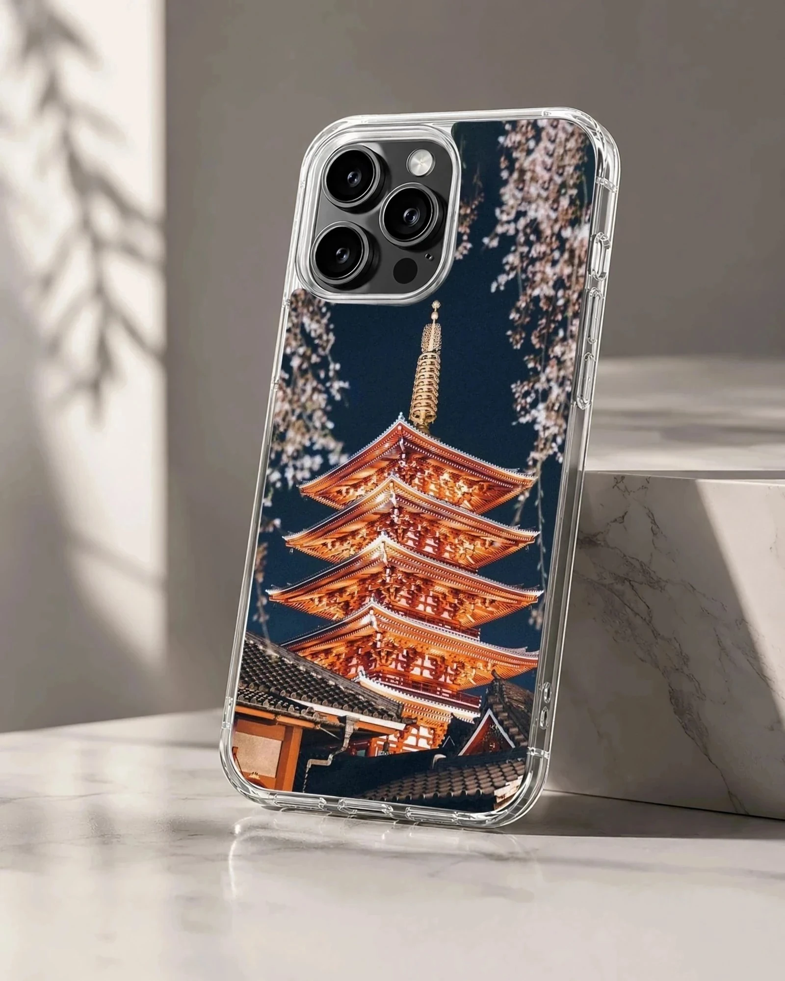 Chinese temple pagoda illuminated at night with cherry blossom branches on a phone case