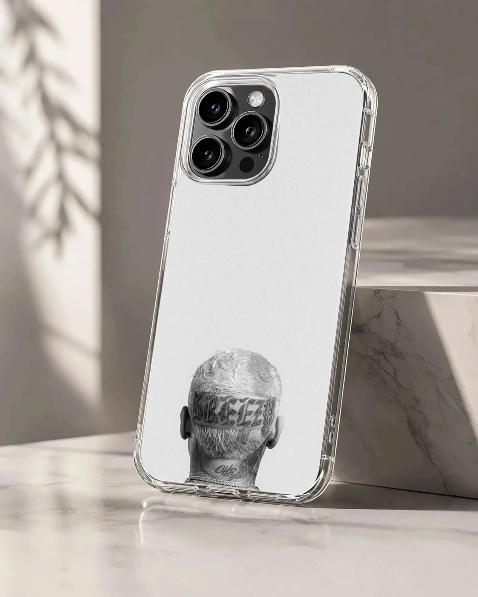 Monochrome photographic print of the back of a head with tattoos and neck lettering on a phone case