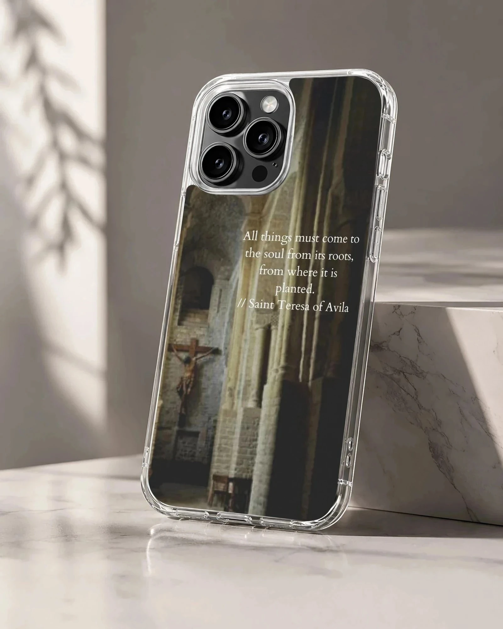 Saint Teresa quote printed over a dimly lit interior stone archway on a phone case