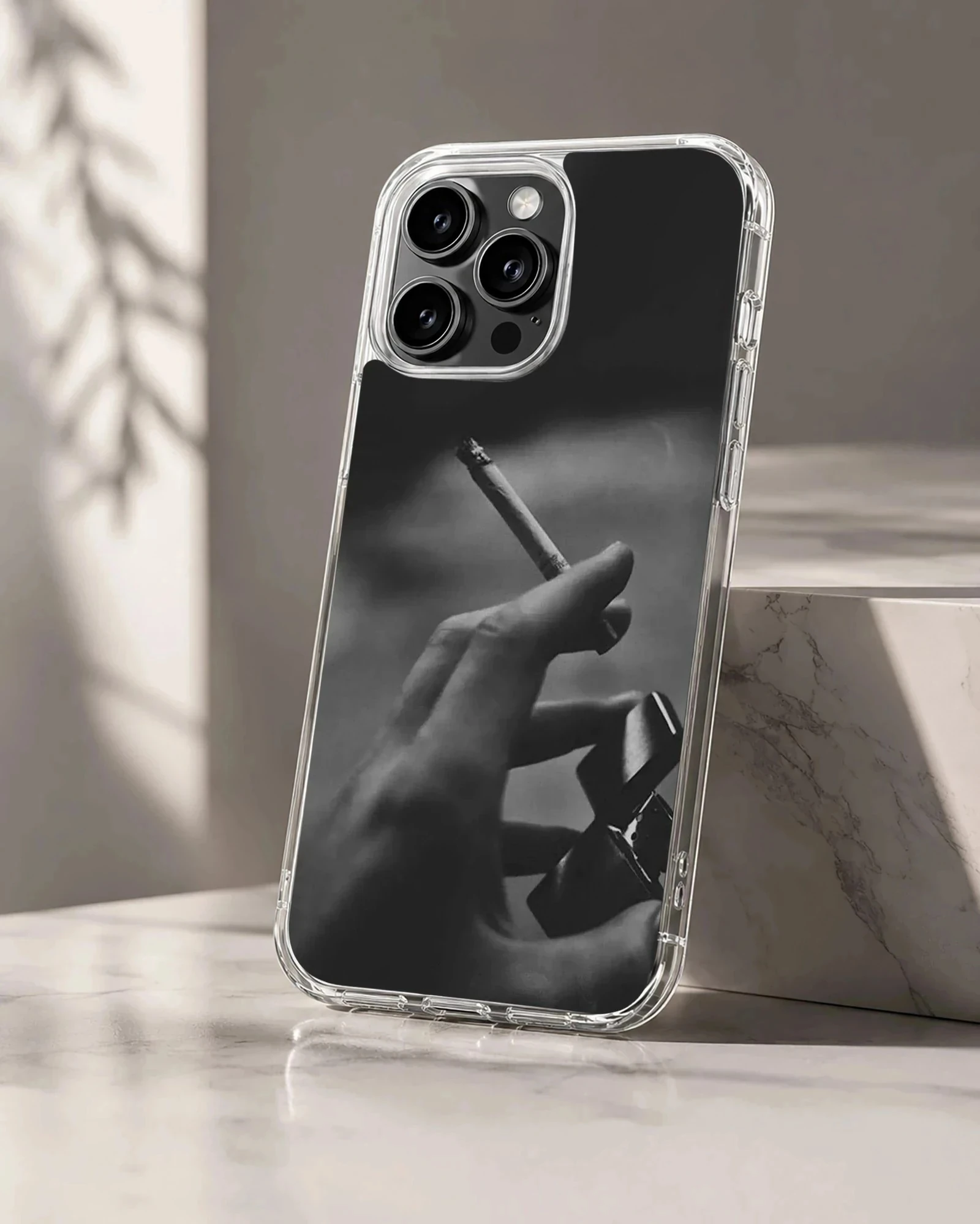 Monochrome photographic print of a hand holding a cigarette and a lighter on a phone case