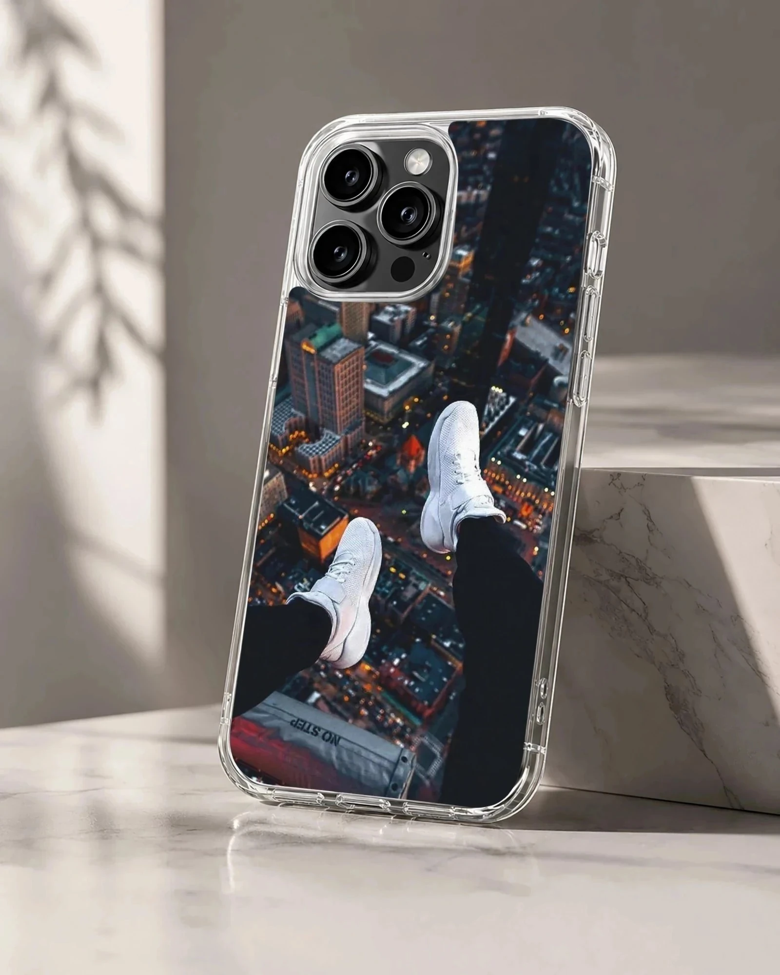 Overhead view of city skyline with dangling white sneakers over lit streets phone case