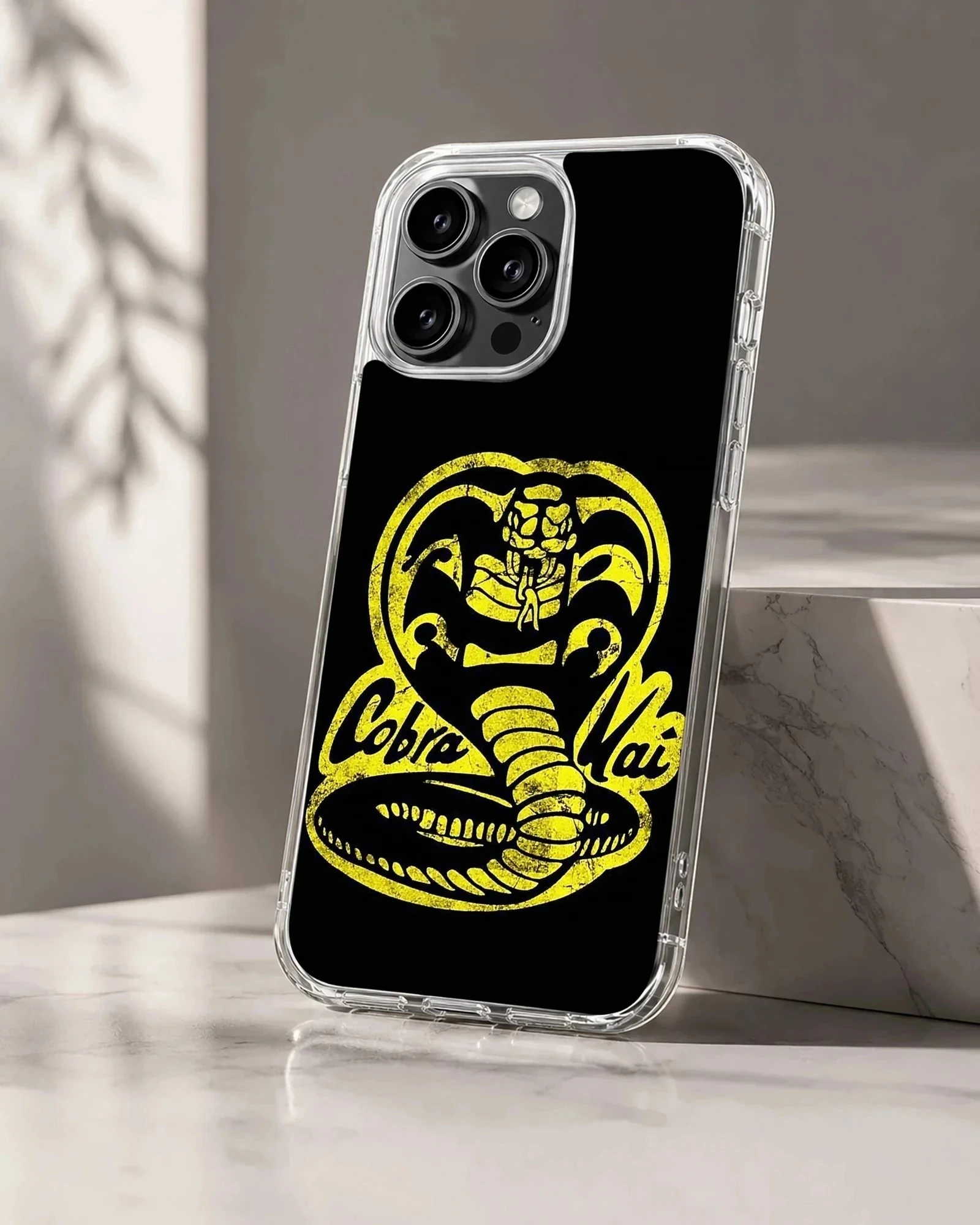 Yellow distressed cobra snake emblem and lettering on a black phone case