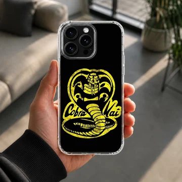 Yellow distressed cobra snake emblem and lettering on a black phone case — Lifestyle