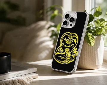 Yellow distressed cobra snake emblem and lettering on a black phone case — Lifestyle