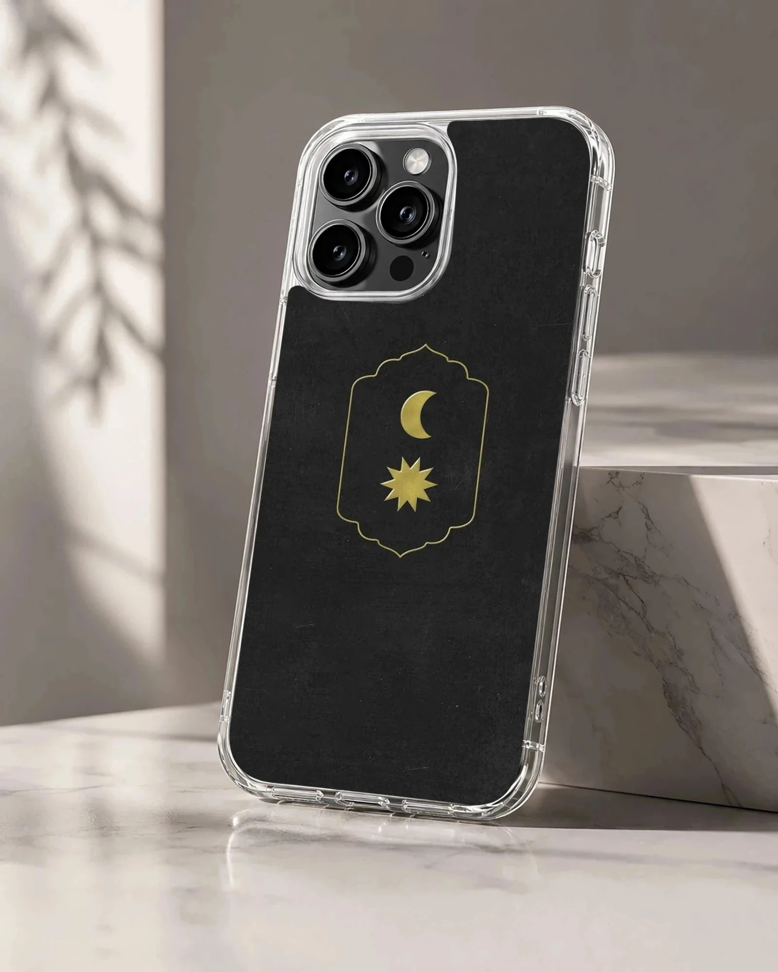 Celestial gold moon and sun emblem on a matte black phone case