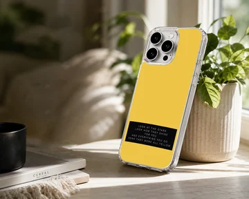 Minimalist yellow phone case featuring a black banner with white song lyric typography. — Lifestyle