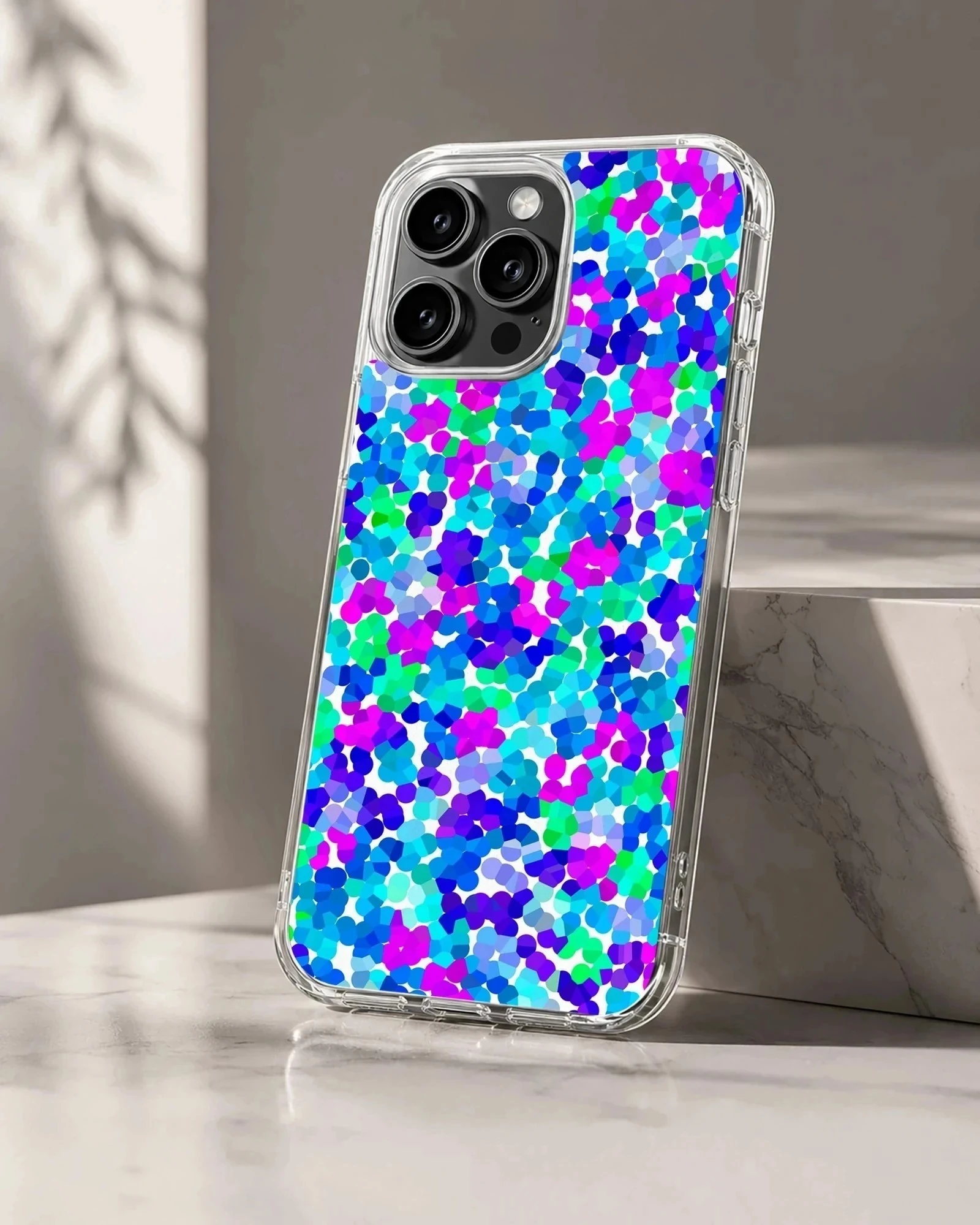 A close-up view of an abstract multicolored dot pattern phone case featuring vibrant blue, purple, and green spots.