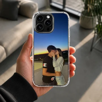 Photographic print of a young couple kissing against a vibrant sunset sky on a snap phone case. — Lifestyle