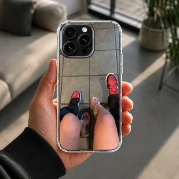 A top-down view of a couple standing together in red sneakers and clear high heels printed on a phone case — Lifestyle