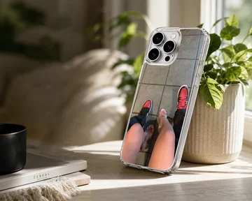 A top-down view of a couple standing together in red sneakers and clear high heels printed on a phone case — Lifestyle