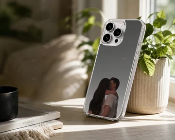 A tender photographic print of a kissing couple embracing against a moody gray sky printed on a protective phone case. — Lifestyle
