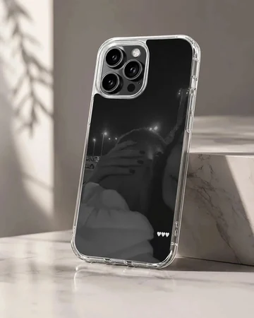 Black and white photographic print of a couple embracing at night with three small white hearts on a phone case.