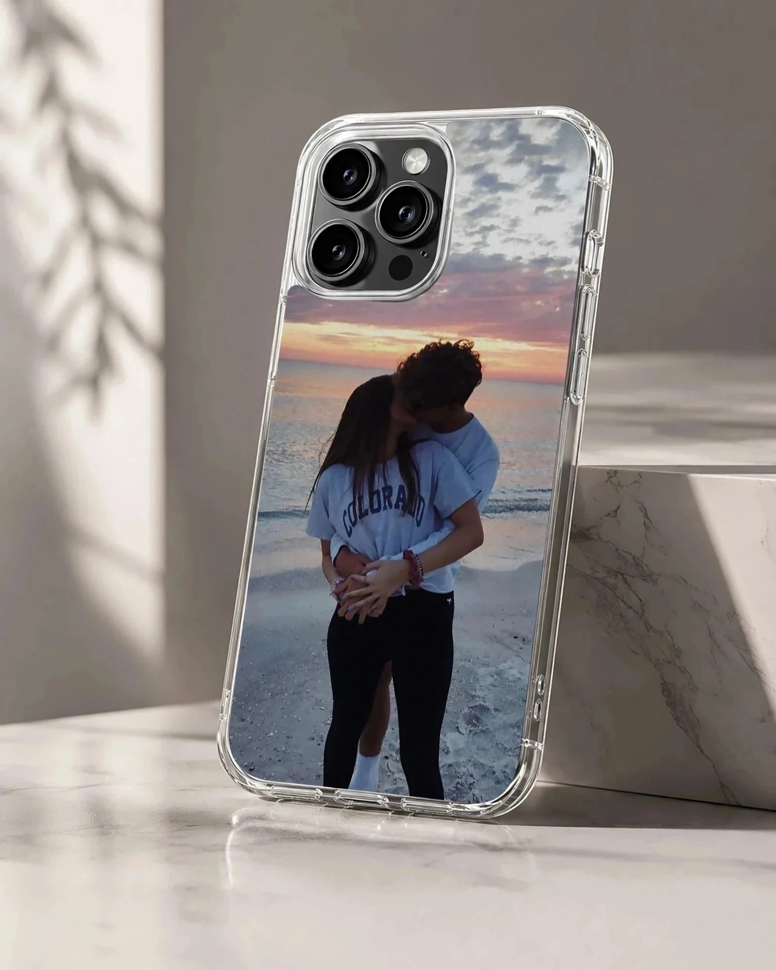 Photographic print of a young couple kissing on a beach at sunset, featured on a matte-finish phone case