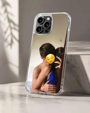 A photograph print on a phone case depicting an embracing couple taking a mirror selfie with a yellow emoji face.