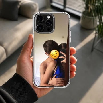 A photograph print on a phone case depicting an embracing couple taking a mirror selfie with a yellow emoji face. — Lifestyle