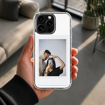 Polaroid-style photo print of a couple making a hand heart during a mirror selfie on a clear phone case. — Lifestyle