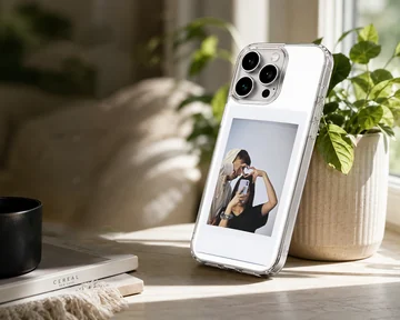 Polaroid-style photo print of a couple making a hand heart during a mirror selfie on a clear phone case. — Lifestyle