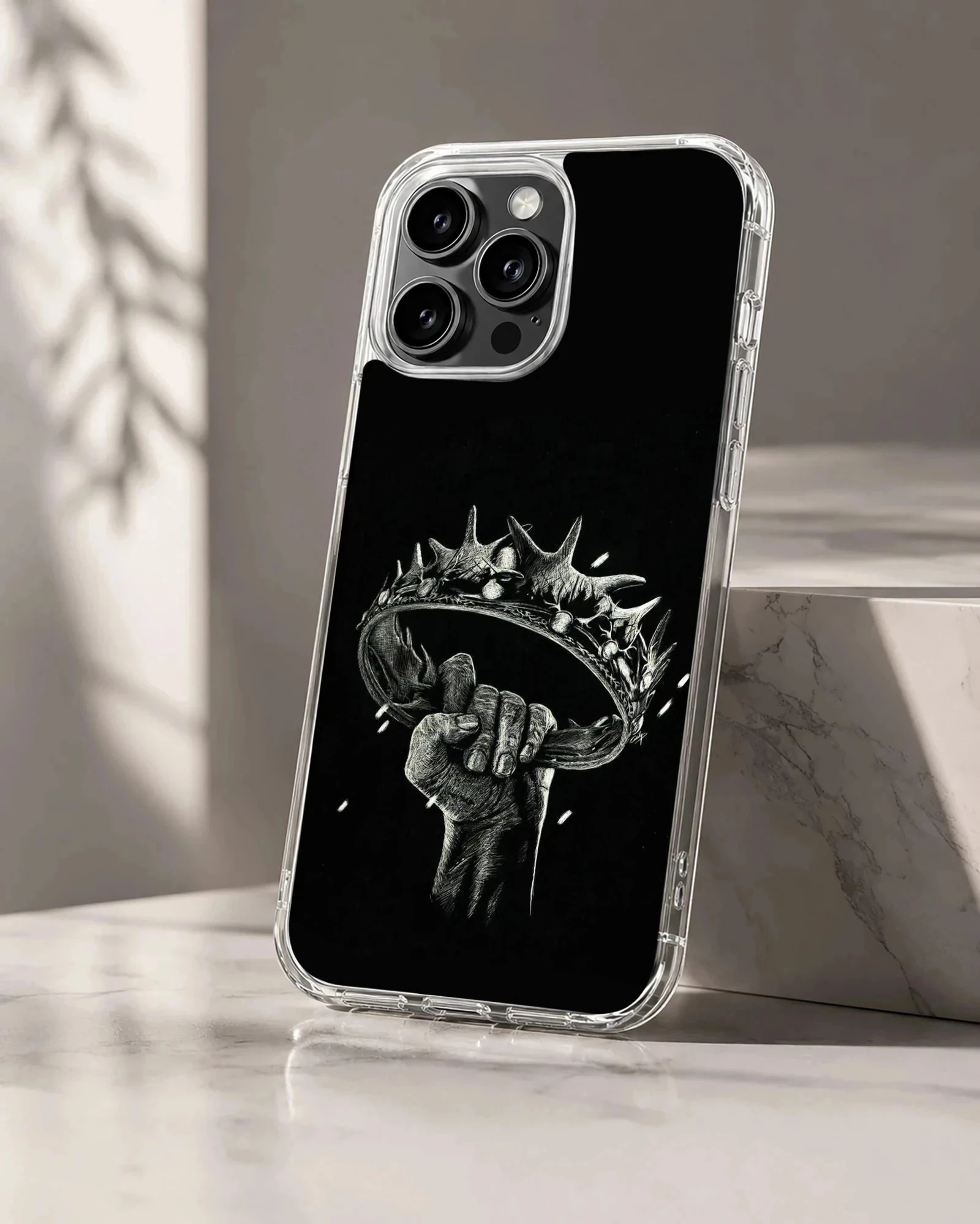 Monochrome sketch of a hand holding a crown printed on a black TPU phone case